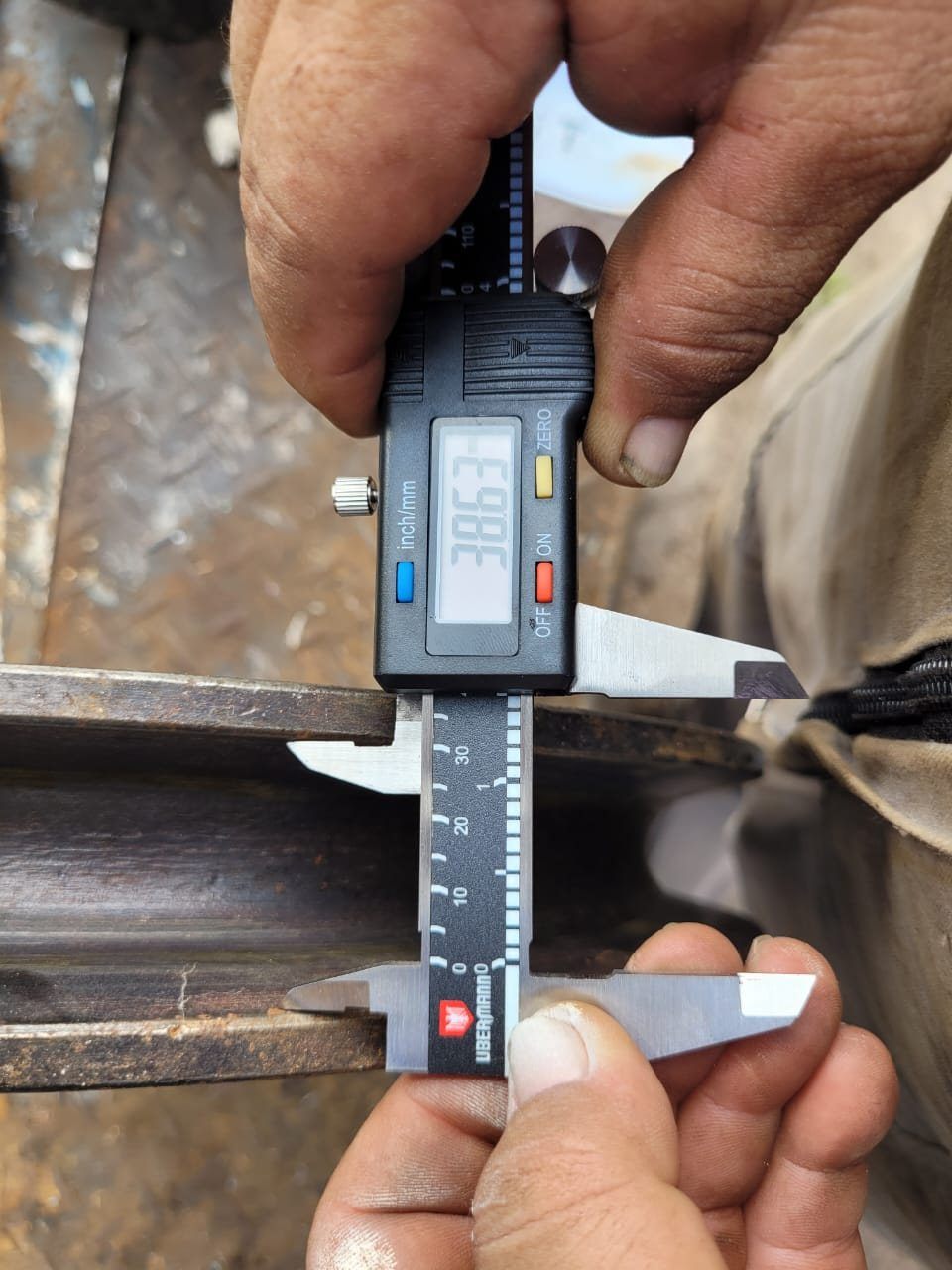 Técnico midiendo con calibre digital el espesor de un componente metálico