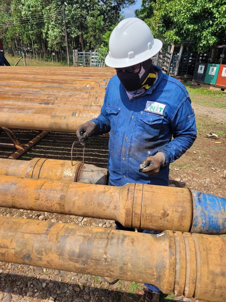 Técnico de National Inspection midiendo una conexión de tubular en el patio de trabajo